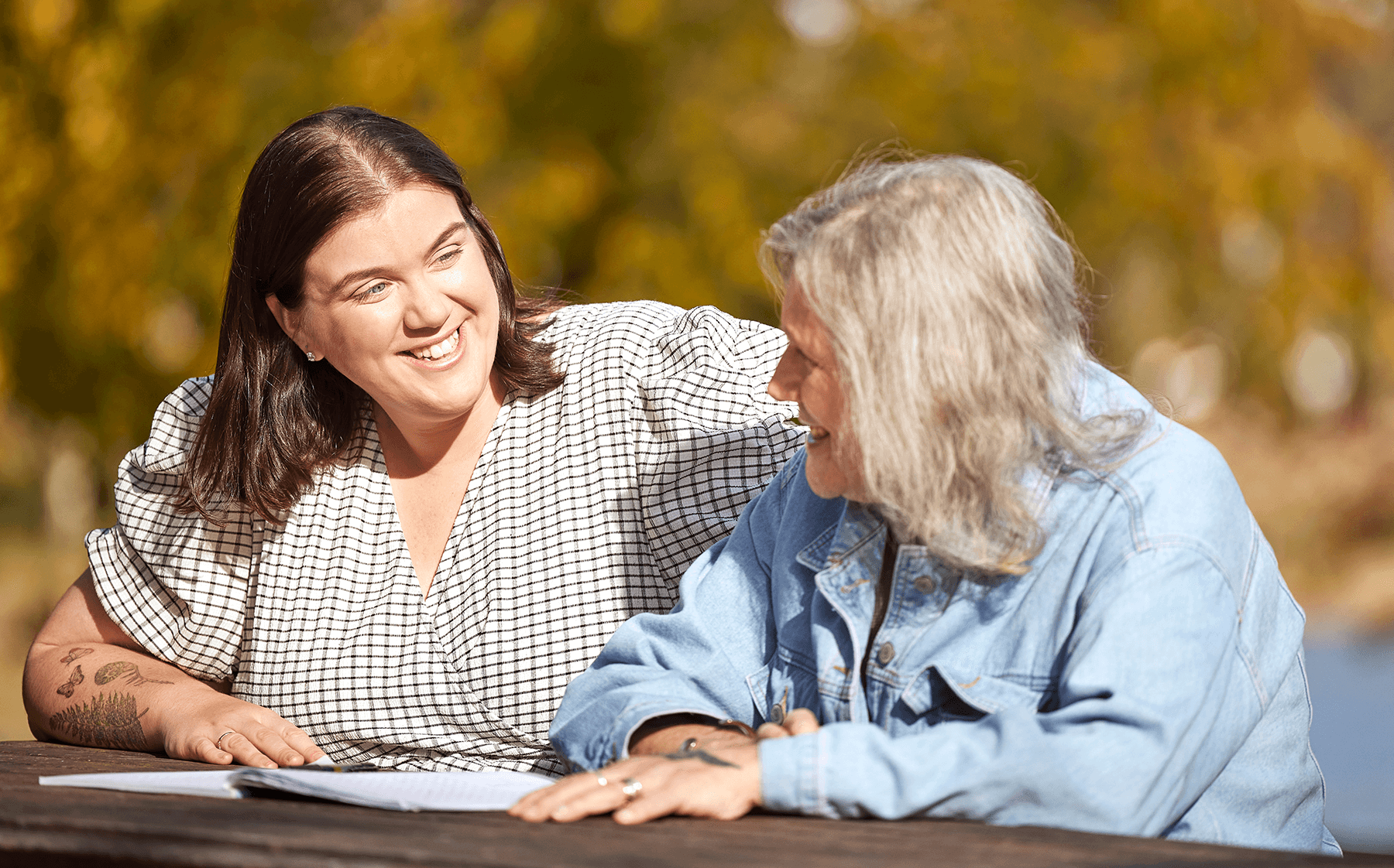 a-woman-sitting-with-her-father-on-a-park-bench
